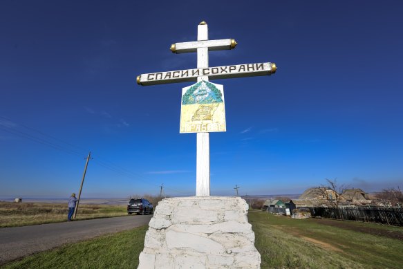 An Orthodox cross with a sign reading Save and Guard, at a memorial to the victims of flight MH17, near Hrabove, in the Russian-controlled Donetsk region of eastern Ukraine.