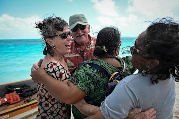 Bunny McDiarmid and Henk Haazen of Greenpeace are joyfully greeted by Irene Abon (green dress) and Henritha Kalles, who were children at the time of the evacuation in 1985.