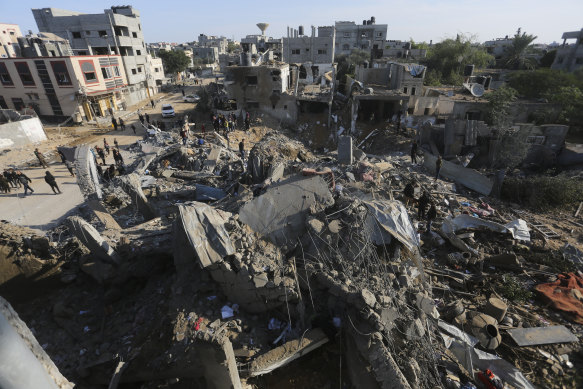 Palestinians look at the destruction by the Israeli bombardment of the Gaza Strip in Rafah.