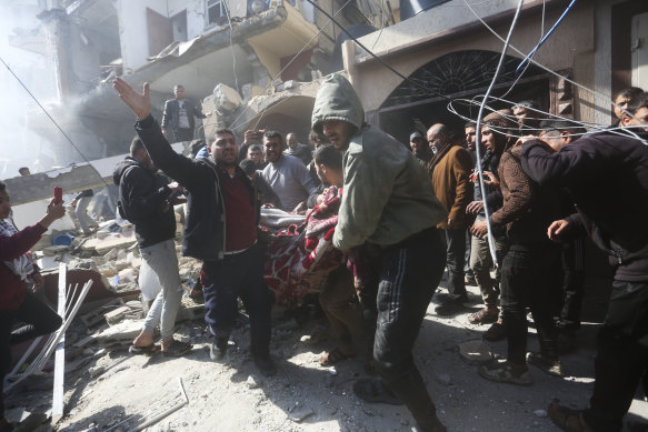 Palestinians rescue survivors after an Israeli strike in Rafah.