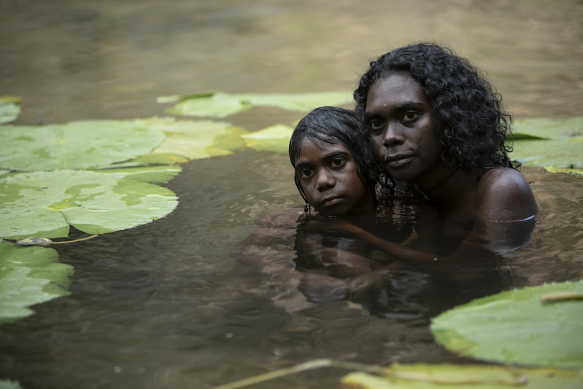 A young Gutjuk (Guruwuk Mununggurr) hiding in a waterhole with his mother Wak Wak (Magnolia Maymuru) during the massacre.