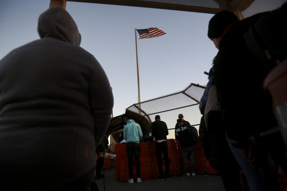 Migrants in Ciudad Juarez, Mexico, near the US border, wait to present  documents requesting asylum in the US.