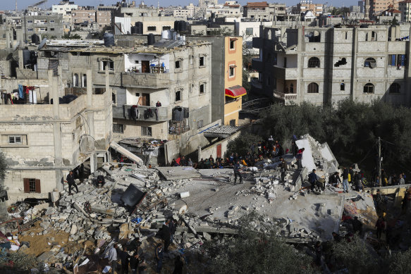 Palestinians look at the destruction after an Israeli strike on a residential building in Rafah, Gaza, on Sunday.