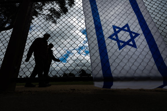 Melburnians walk past an Israeli flag flying in Caulfield Park.