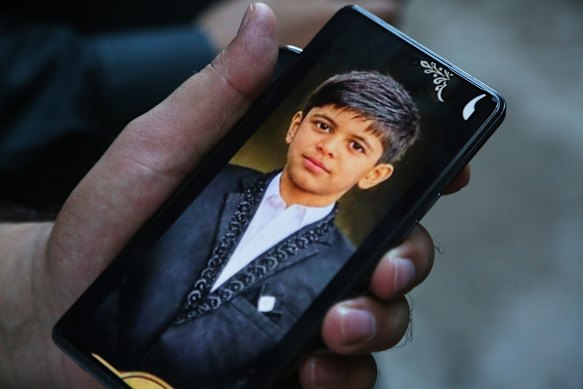 A man shows a picture of his young relative who was killed in the roof collapse.