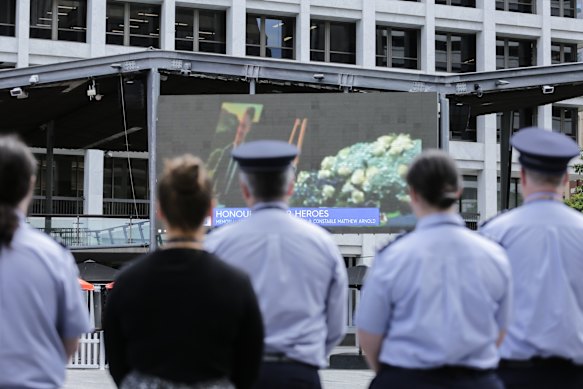 Police gather in King George Square on December 21 to watch the memorial for constables Rachel McCrow, 29, and Matthew Arnold, 26, killed alongside local man Alan Dare.