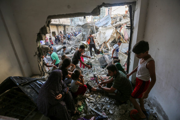 People search through buildings that were destroyed during Israeli air raids in Khan Yunis, southern Gaza, on Thursday.