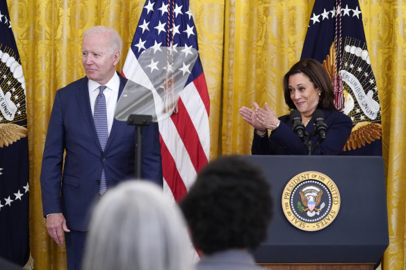 US Vice President Kamala Harris applauds as President Joe Biden looks on.