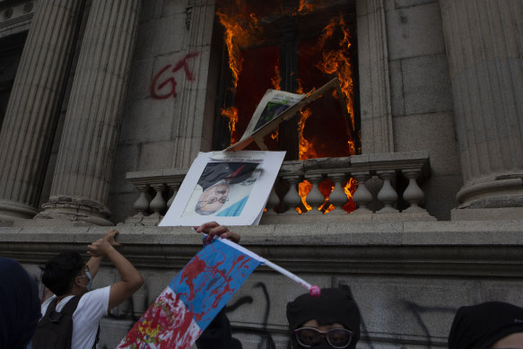 An official photo of former Congress President Eduardo Meyer is thrown out from the Congress building after protesters set a part of the building on fire, in Guatemala City, on Saturday, November 21.