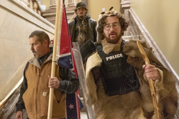 Insurrectionists loyal to President Donald Trump storm the US Capitol building on January 6 carrying a Confederate flag.