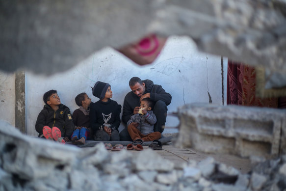 Mahmoud Al-Durra takes care of his four children in Rafah, Gaza, on Wednesday. His wife was killed and his home destroyed in the conflict with Israel.