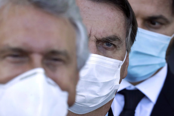 Brazilian President Jair Bolsonaro, centre, arrives for a press conference following a ministerial meeting about his government’s handling of the pandemic.