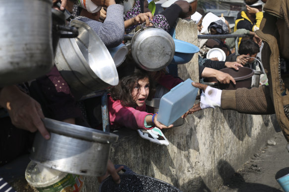 Palestinians line up for food amid the Israeli air and ground offensive.