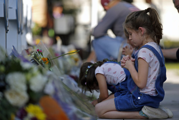 Children pray and pay their respects at a memorial site for the victims killed in this week’s elementary school shooting in Uvalde, Texas.