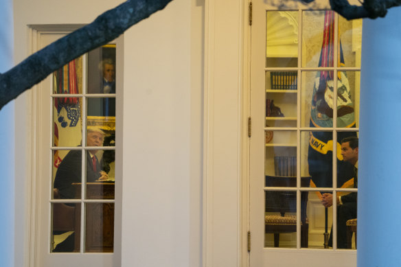 President Donald Trump sits in the Oval Office with White House director of the Presidential Personnel Office John McEntee, right, after the vaccine press conference.