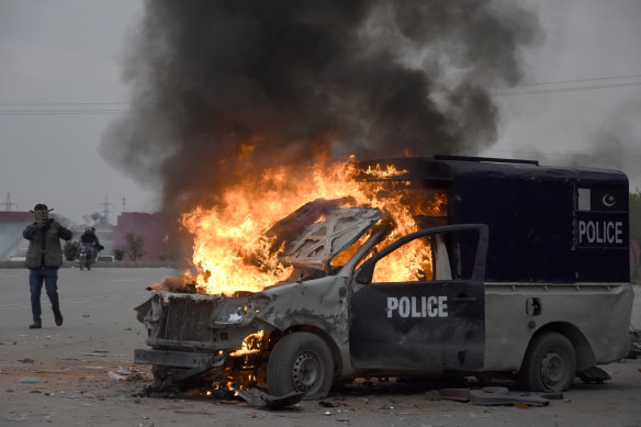 A police van burns following clashes between police and Imran Khan’s supporters outside an Islamabad court.