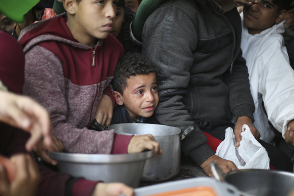 Palestinians line up for free food distribution during the ongoing Israeli air and ground offensive in Khan Younis, Gaza Strip, last month.