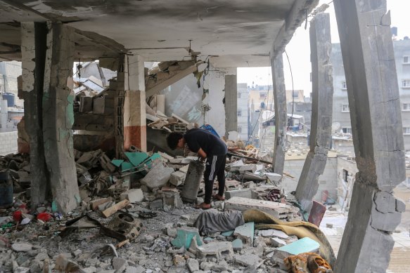 People search through buildings that were destroyed during Israeli air raids in the southern Gaza Strip on October 28.