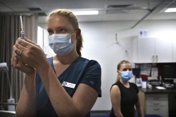 A nurse prepares a dose of flu vaccine for patient Bronte May-Horswood at the O’Connell Centre Medical Practise in the Sydney CBD.