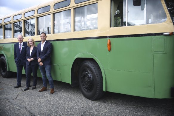 Transport for NSW chief operations officer Howard Collins, left, Metropolitan Roads Minister Natalie Ward and Sydney MP Alex Greenwich in front of a vintage bus, which will cross the bridge as part of the celebrations.