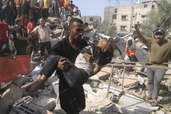 A man carries a Palestinian girl pulled out of the de house destroyed in the Israeli bombardment of the Gaza Strip in Rafah.