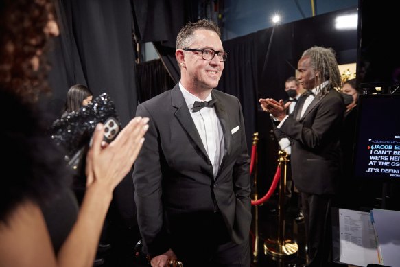 Greig Fraser walks backstage at the Oscars after winning.
