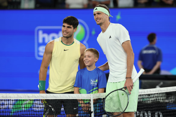 Carlos Alcaraz of Spain and Alexander Zverev of Germany pose with a ball kid.