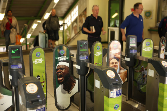 Tennis fans pour through the tennis-themed turnstiles at Southfields underground station in London.