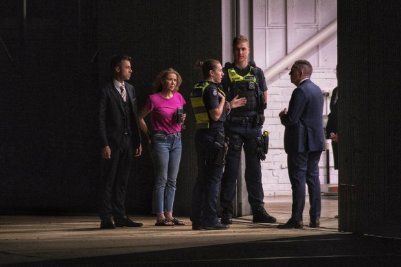 Warne’s personal assistant Helen Nolan with police officers. 