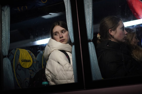 A young girl, who has fled Ukraine, looks out of the window of a bus as she prepares to travel to Przemysl after arriving at the border crossing in Medyka, Poland, on Sunday.