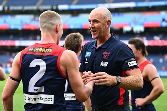 Demons coach Steven King celebrates with forward Jacob van Rooyen after their round one victory.