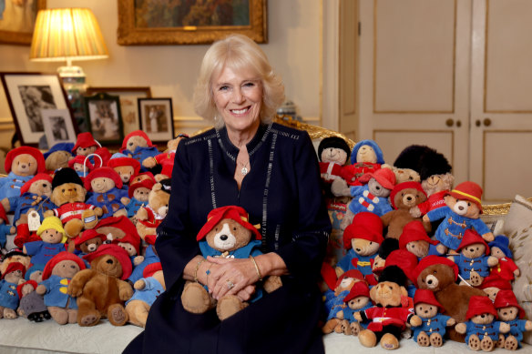 Camilla, Queen Consort, poses with a collection of Paddington cuddly toys at Clarence House.