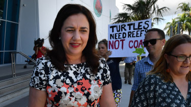 Queensland Premier Annastacia Palaszczuk walks past an anti-Adani coal mine protester as she leaves the Cairns Aquarium on Wednesday.