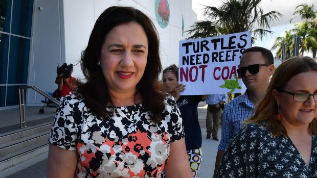 Queensland Premier Annastacia Palaszczuk walks past an anti-Adani coal mine protester as she leaves the Cairns Aquarium on Wednesday.
