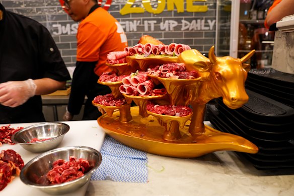 Hand-cut beef is served on a giant gold cow. 