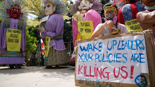 Environmental activists display posters as performers dance in traditional giant effigies called “ondel-ondel” during a climate strike rally in Jakarta on Sunday.