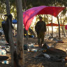 Israeli soldiers search for ID and belongings among the cars and tents at the Supernova Music Festival site on October 12.