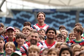Mark Nawaqanitawase and Roosters teammates pose with juniors at Allianz Stadium.