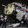 FILE - Presiding judge Hendrik Steenhuis, right, other trial judges and lawyers view the reconstructed wreckage of Malaysia Airlines Flight MH17, at the Gilze-Rijen military airbase, southern Netherlands, on May 26, 2021. (AP Photo/Peter Dejong, Pool, File)