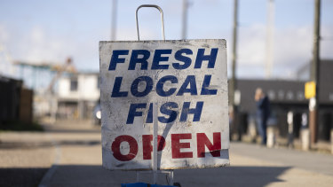 A sign advertising ‘fresh local fish’ stands in the harbour in Hastings, England. 