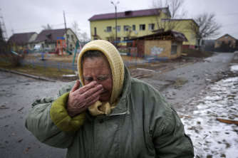 A woman cries outside houses damaged by a Russian airstrike in Gorenka, outside the capital Kyiv, Ukraine.