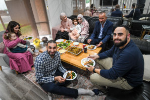 Adnan Hanna, on rear couch at right, visits his neighbour, Imam Alaa Elzokm (front, in check shirt) and his family for an Eid al-Fitr meal in Roxburgh Park on Monday.