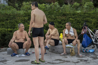 Yüzücüler, Pekin'deki Liangma Nehri'nin yanındaki popüler bir yüzme alanında sohbet ediyor.