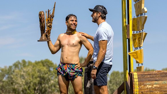 Mladenov, holding his team’s challenge trophy, with Australian Survivor host Jonathan LaPaglia. 