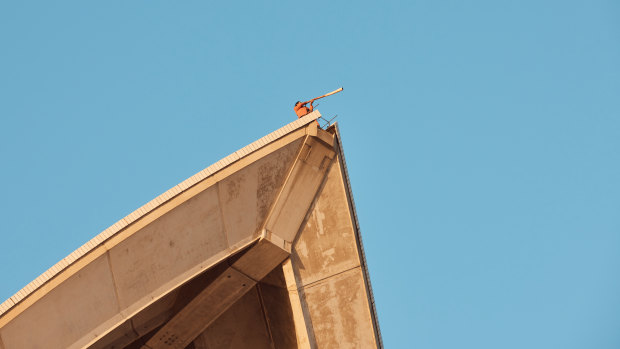 William Barton plays didgeridoo atop the Opera House sails as part of the video which celebrates the building’s 50th anniversary.
