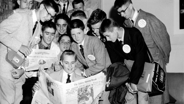 Visiting American paper boys compare the Los Angeles Examiner with the Sydney Morning Herald at Mascot Airport in 1958