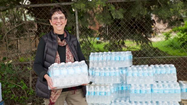 Local resident Jenny Evans picks up a stash of bottled water, which has been provided for all Uralla residents since December.
