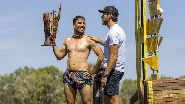 Mladenov, holding his team’s challenge trophy, with Australian Survivor host Jonathan LaPaglia. 