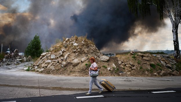 A woman walks near the scene of a Russian air raid on a warehouse on the outskirts of Kyiv.