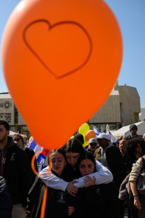 A crowd watches a live feed from a funeral for members of the Bibas family in Tel Aviv.